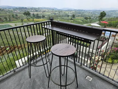 Dua meja bar di balkon villa, menghadap hamparan ladang dan perbukitan Guci. Nyaman buat work from villa :)