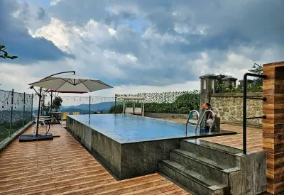 Kolam renang infinity air panas alami Del Luna dengan payung dan dek motif kayu, menghadap perbukitan dan ladang teras siring Guci